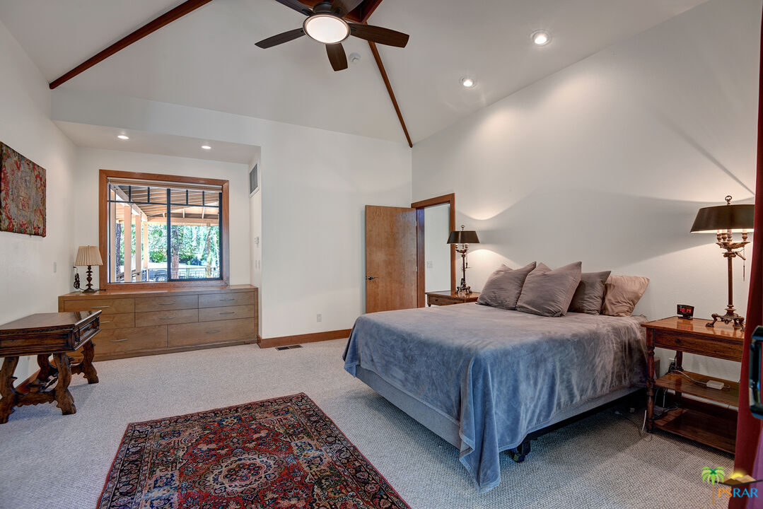 25445 Fern Valley Road Idyllwild, CA 92549 - Photo 31 of 52 a bedroom with a bed and a chandelier