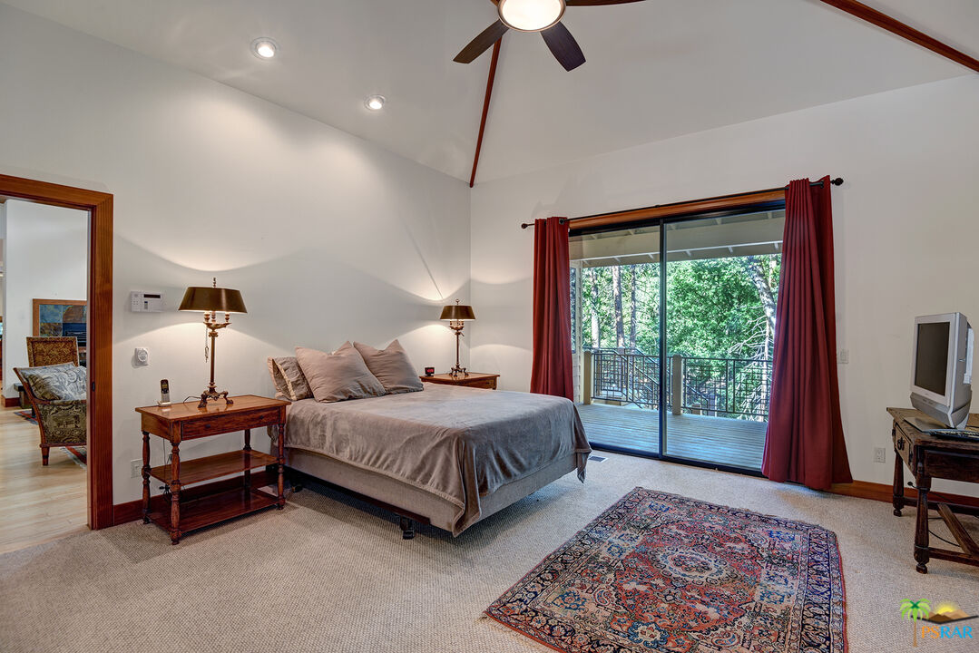 25445 Fern Valley Road Idyllwild, CA 92549 - Photo 32 of 52 a bedroom with a bed lamps and a large window