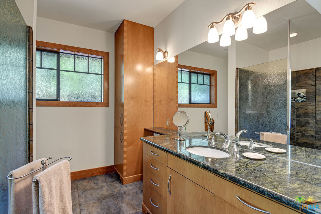 25445 Fern Valley Road Idyllwild, CA 92549 - Photo 36 of 52 a bathroom with a granite countertop sink a mirror and a shower