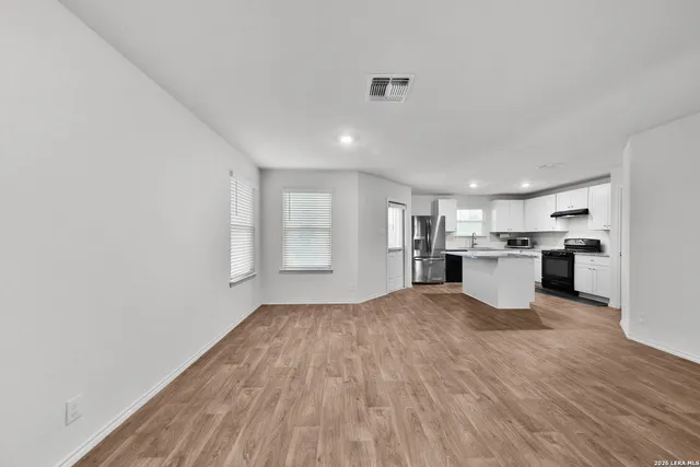 a view of a kitchen with wooden floor and windows