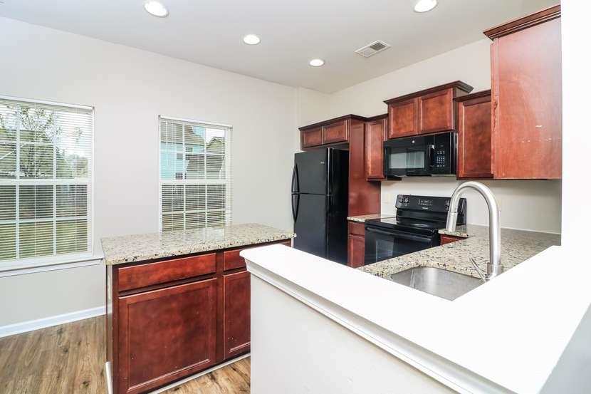 113 Howard Avenue Cartersville, GA 30121 - Photo 11 of 17 a kitchen with stainless steel appliances a sink a stove a refrigerator a cabinets and wooden floor