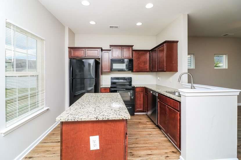 113 Howard Avenue Cartersville, GA 30121 - Photo 12 of 17 a kitchen with stainless steel appliances granite countertop a sink stove and refrigerator