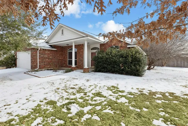 a view of a house with a yard covered in snow