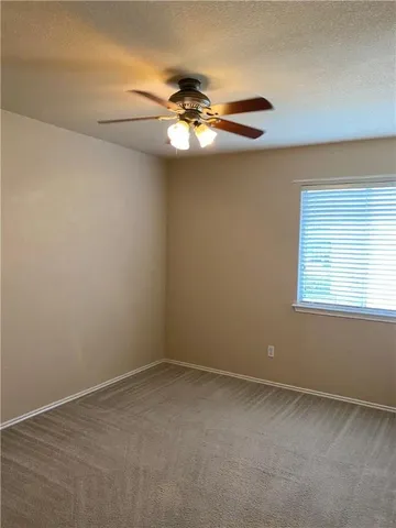 a view of a livingroom with a ceiling fan and window