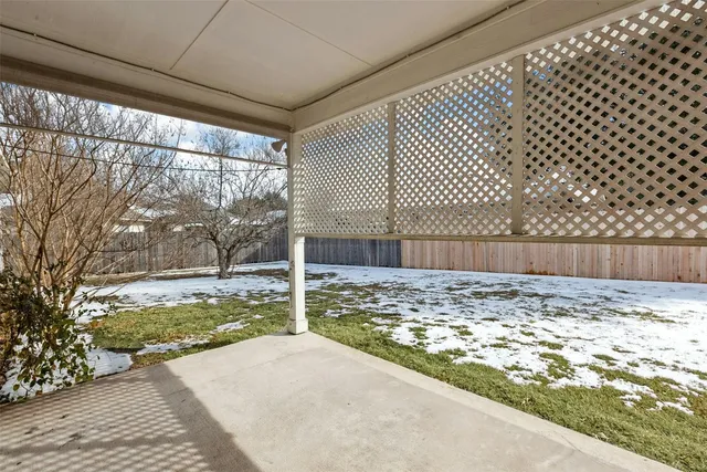a view of a yard with wooden fence