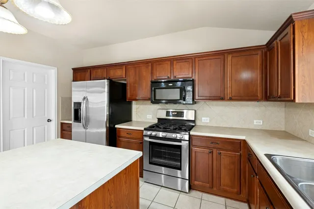 a kitchen with stainless steel appliances a stove microwave and refrigerator