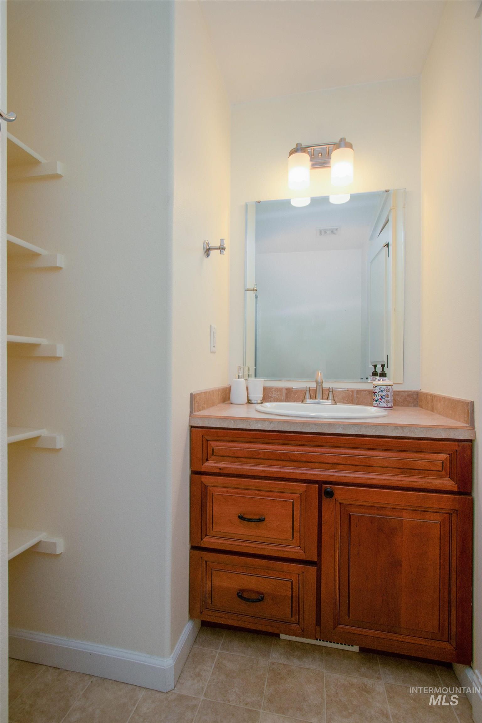 892 South Capitola Way Boise, ID 83712 - Photo 22 of 34 Recessed vanity with a light-toned countertop, integrated sink, and an overhead light fixture