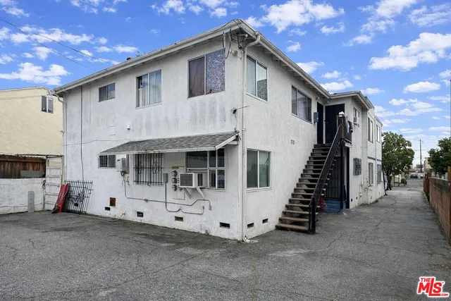 a view of a white house with many windows and a tree