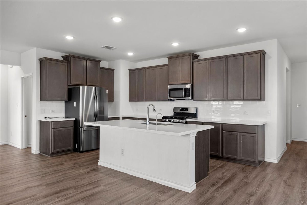 500 Stinchcomb Road Hutto, TX 78634 - Photo 13 of 37 A well-appointed kitchen features a large island and ample cabinetry, ideal for culinary creations and gatherings.