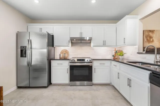 a kitchen with stainless steel appliances granite countertop a refrigerator sink and cabinets