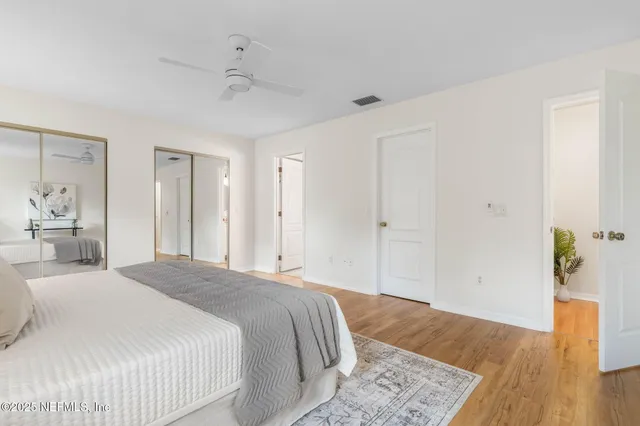a spacious bedroom with a bed and wooden floor