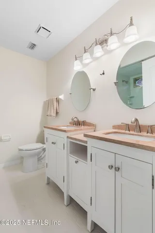 a bathroom with a double vanity sink and a mirror