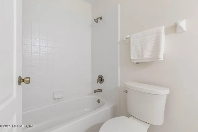 a white toilet sitting next to a bath tub