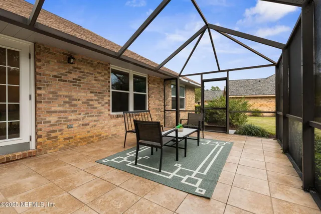 a patio with glass top table and chairs