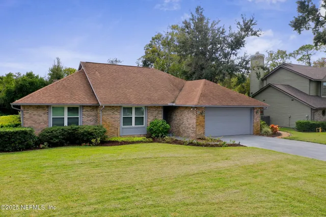 a front view of a house with yard and green space