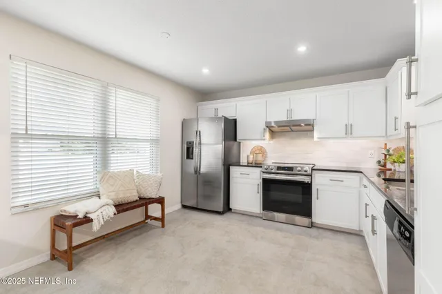 a kitchen with stainless steel appliances granite countertop a stove and a refrigerator