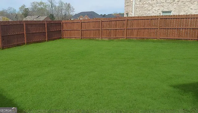 a view of a backyard with wooden fence