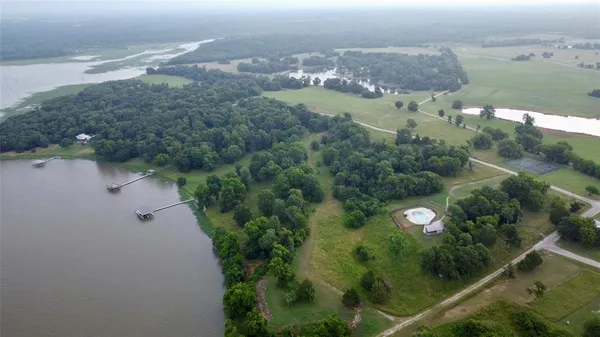 an aerial view of a house with a yard and lake view