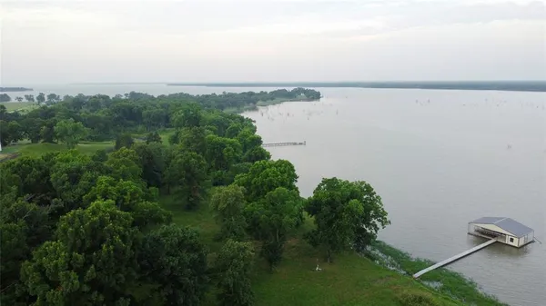an aerial view of a house with a yard and lake view