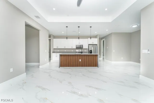 a large kitchen with a large counter top cabinets and stainless steel appliances