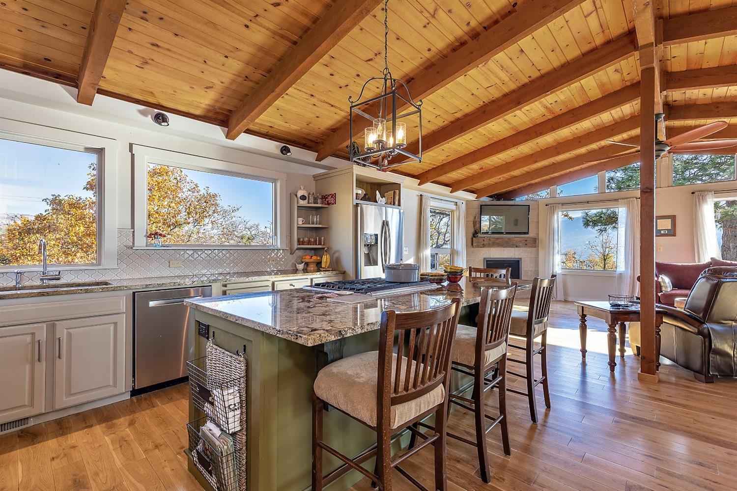 1876 North Valley View Road Ashland, OR 97520 - Photo 8 of 35 a dining hall with stainless steel appliances granite countertop a stove a sink dishwasher and chairs with wooden floor