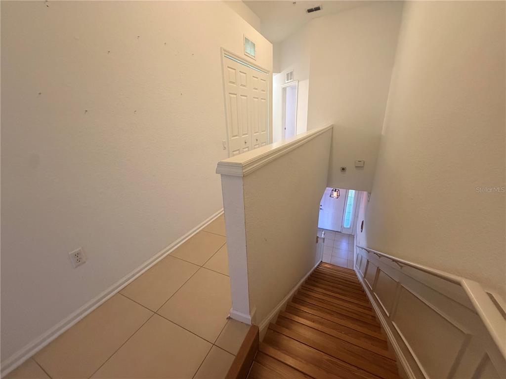 2837 Villafuerte Point, Unit 105 Orlando, FL 32835 - Photo 11 of 23 a view of a hallway with wooden floor and staircase