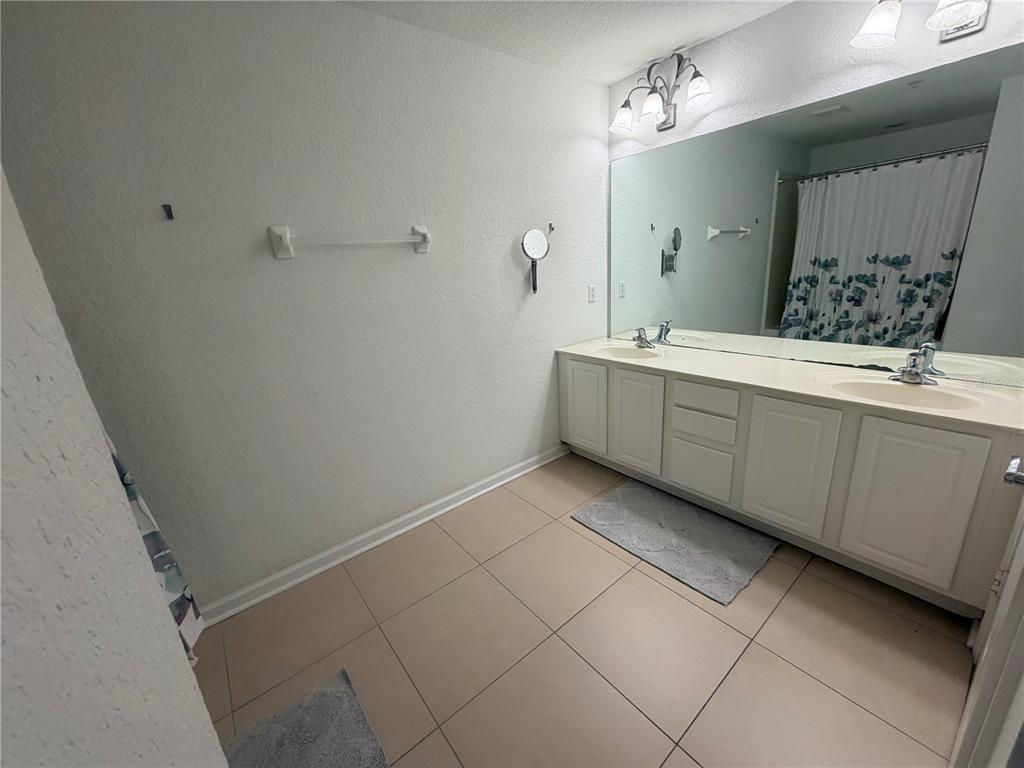 2837 Villafuerte Point, Unit 105 Orlando, FL 32835 - Photo 14 of 23 a bathroom with a sink and mirror