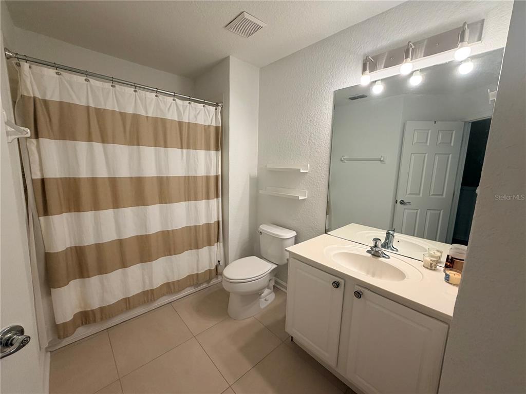 2837 Villafuerte Point, Unit 105 Orlando, FL 32835 - Photo 21 of 23 a bathroom with a sink toilet and shower