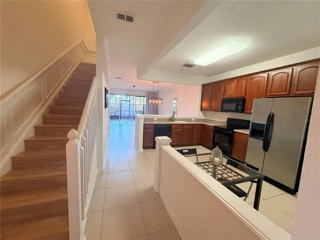 a kitchen with granite countertop a refrigerator and a stove top oven
