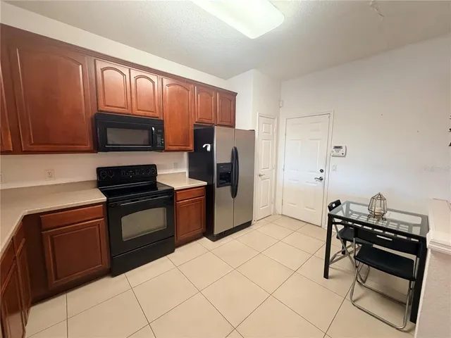 a kitchen with stainless steel appliances a stove a sink and a refrigerator with cabinets