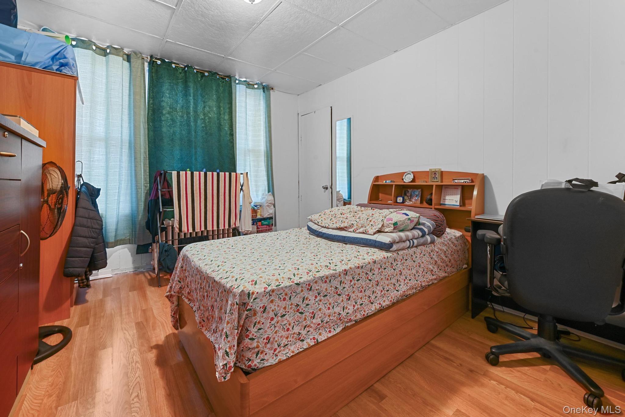 90-16 76th Street Queens, NY 11421 - Photo 12 of 28 a bedroom with a bed chair and a window