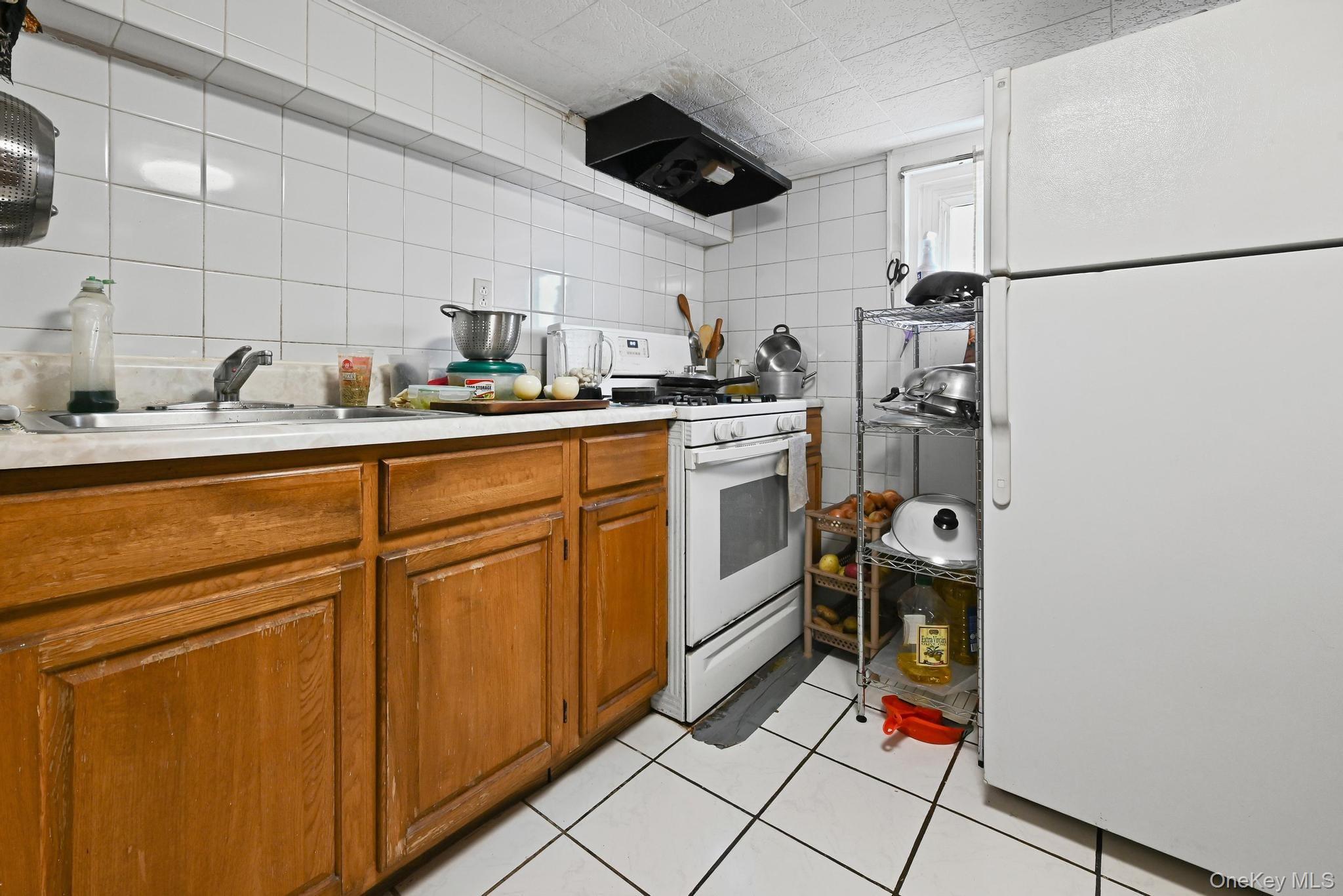90-16 76th Street Queens, NY 11421 - Photo 15 of 28 a kitchen with stainless steel appliances granite countertop a sink stove and refrigerator