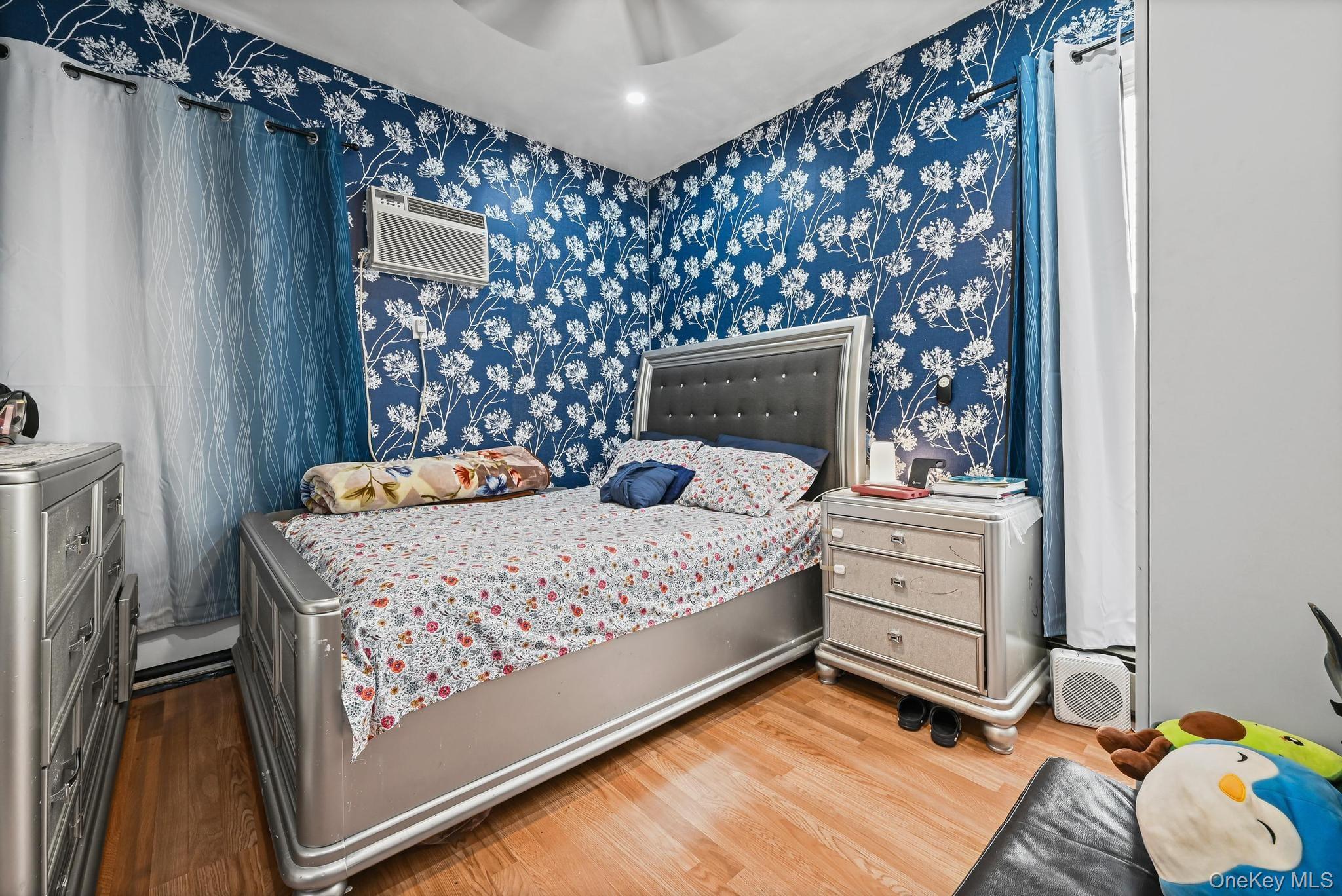 90-16 76th Street Queens, NY 11421 - Photo 16 of 28 a bedroom with a bed and a flat tv screen on dresser