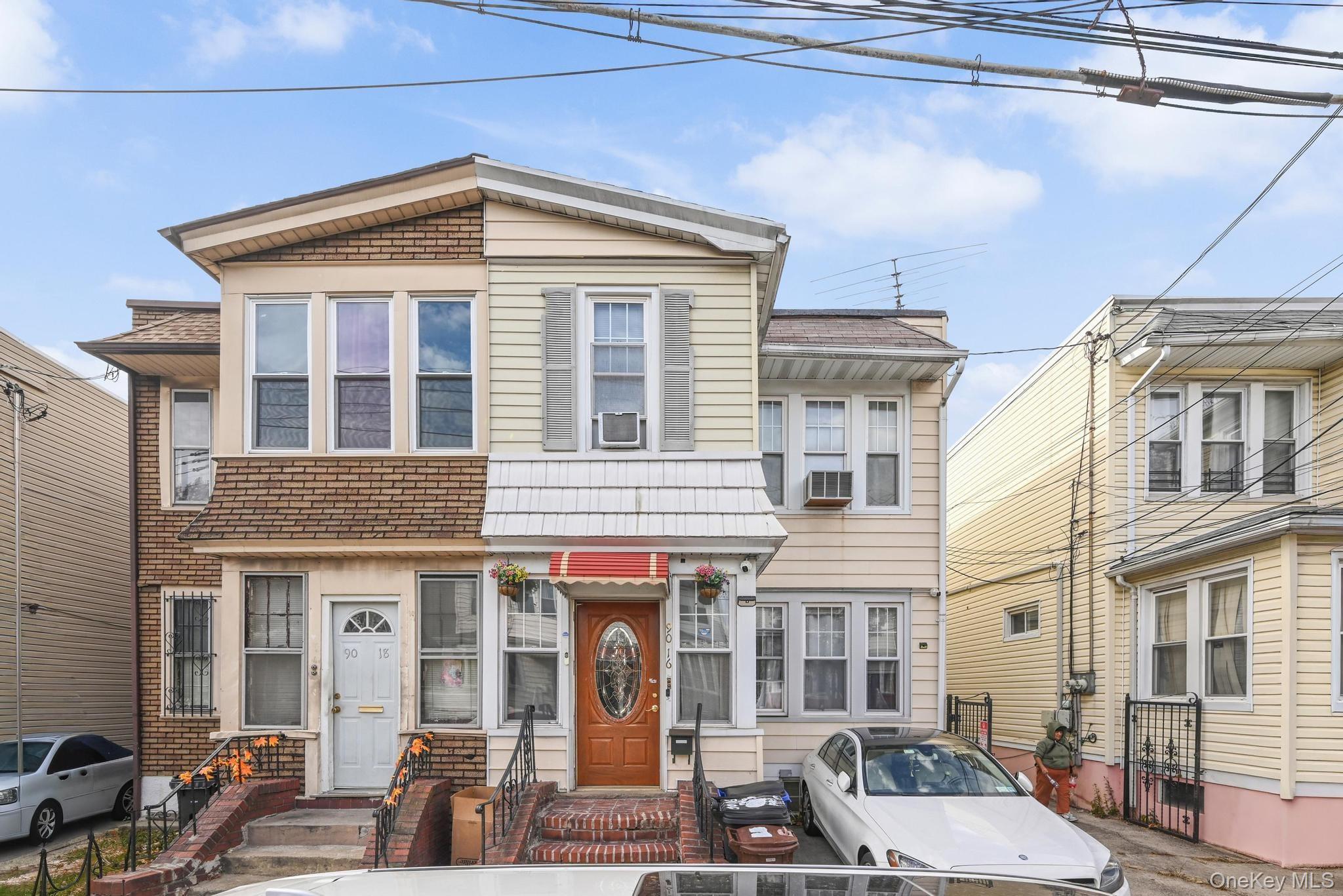 90-16 76th Street Queens, NY 11421 - Photo 25 of 28 a front view of a residential apartment building with a yard