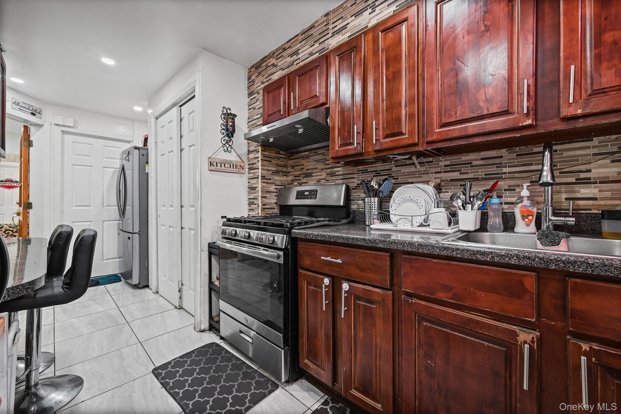 90-16 76th Street Queens, NY 11421 - Photo 4 of 28 a kitchen with granite countertop a sink appliances and cabinets