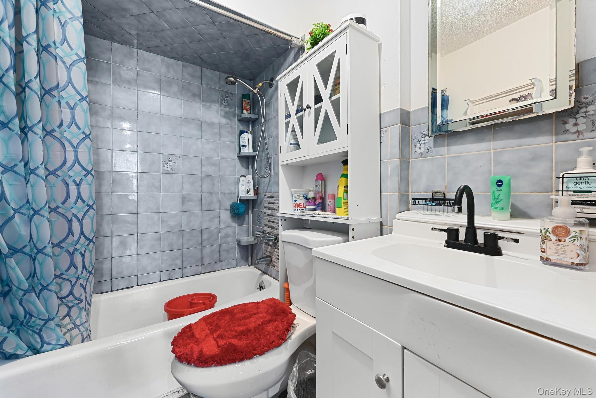 90-16 76th Street Queens, NY 11421 - Photo 7 of 28 a bathroom with a sink a toilet and a shower