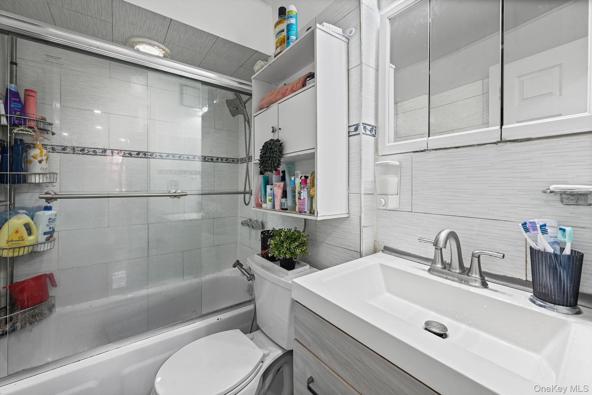 90-16 76th Street Queens, NY 11421 - Photo 8 of 28 a bathroom with a sink vanity granite toilet and shower