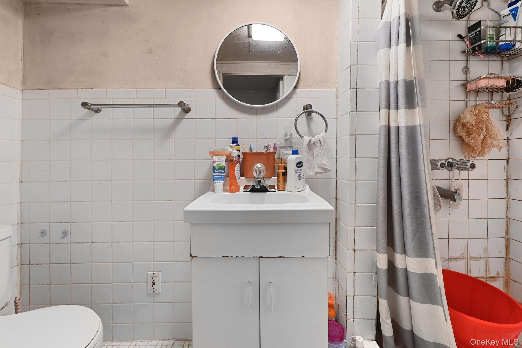 90-16 76th Street Queens, NY 11421 - Photo 9 of 28 a bathroom with a toilet and a sink
