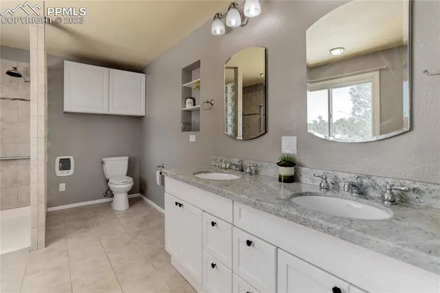 a bathroom with a granite countertop sink mirror and toilet