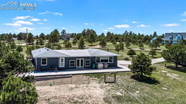 a view of a house with a garden and sitting area