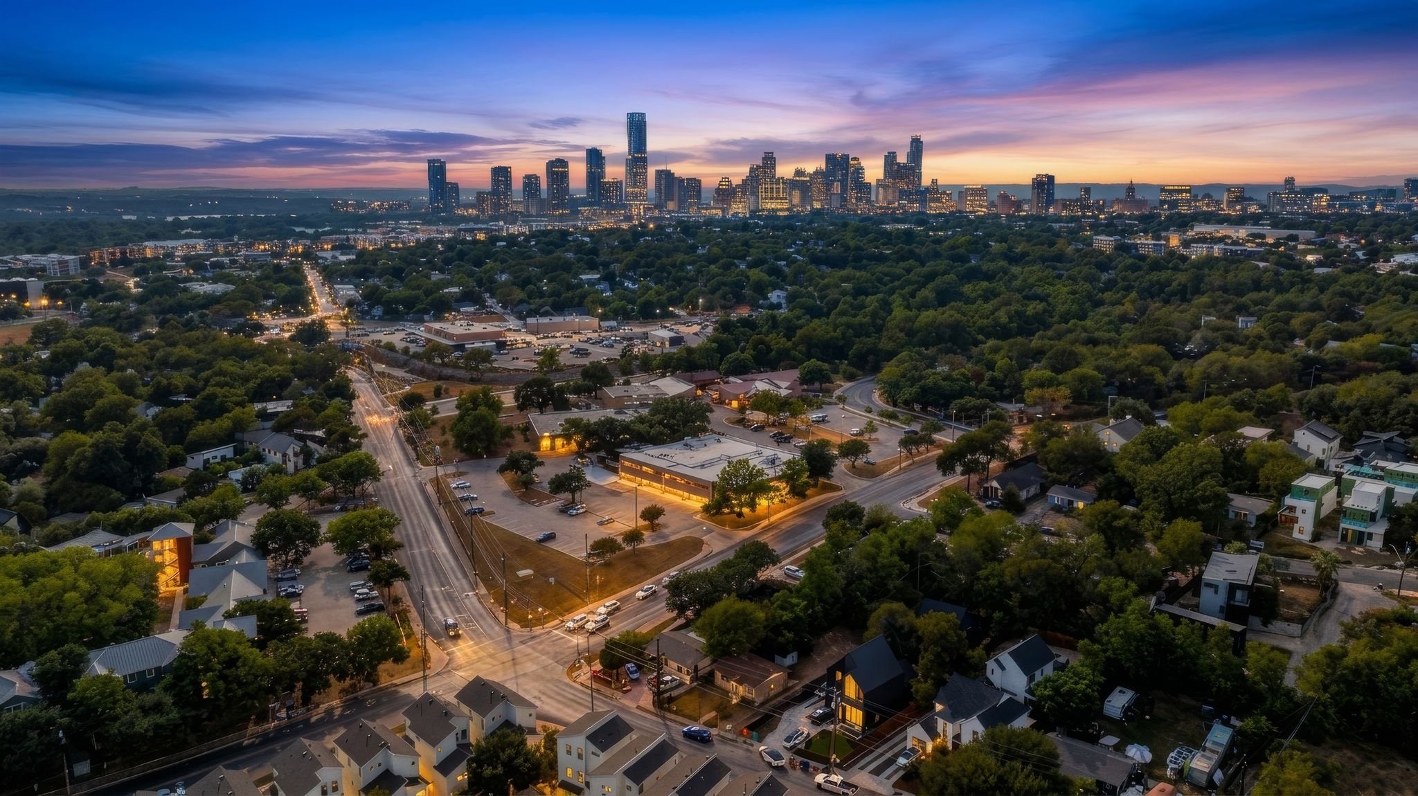 2900 Webberville Road Austin, TX 78702 - Photo 2 of 22 Dramatic sunset skies frame a panoramic view of the distant city skyline over lush neighborhoods.