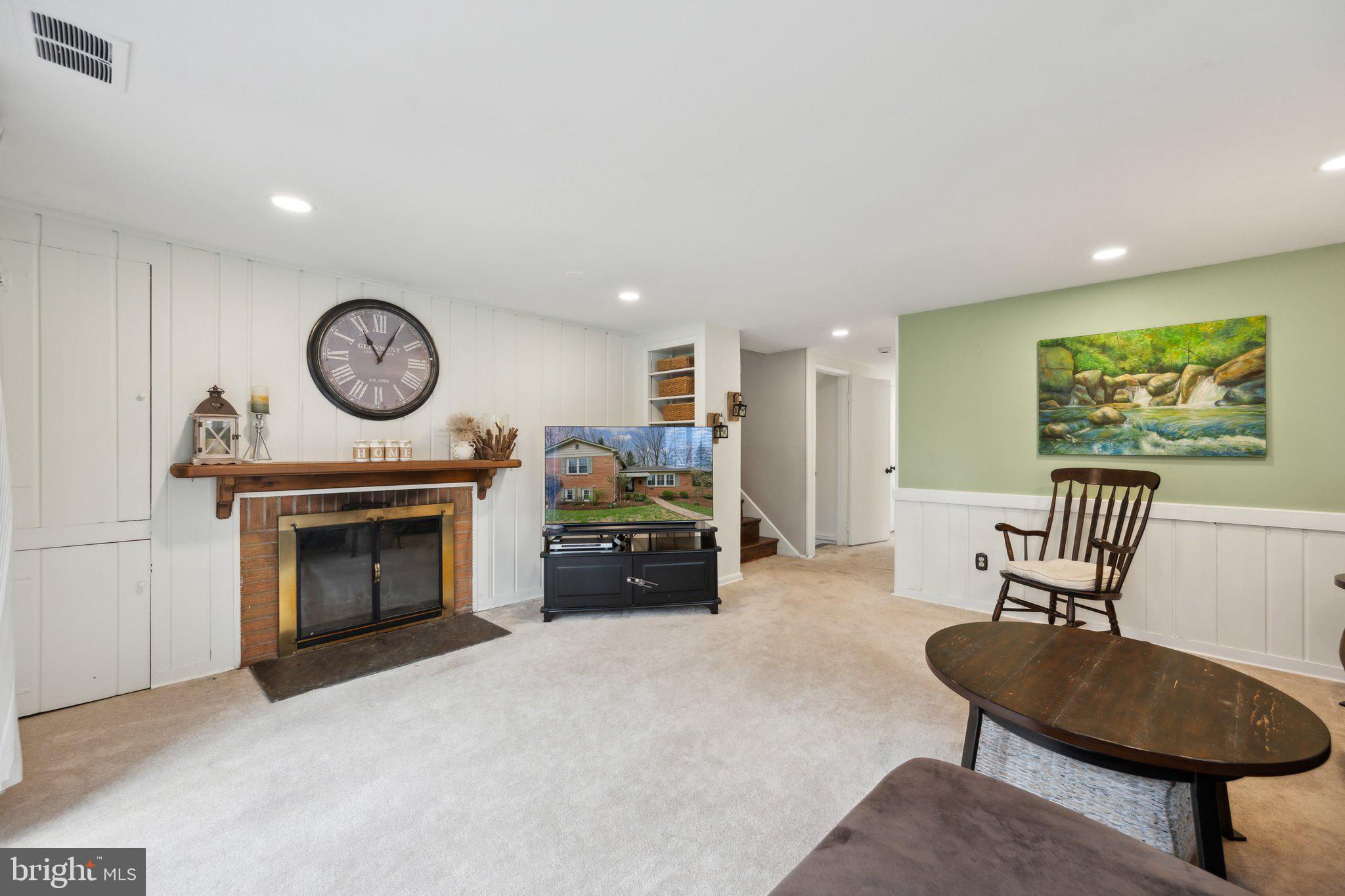 10601 Meadowhill Road Silver Spring, MD 20901 - Photo 20 of 33 a living room with furniture a clock and a fireplace