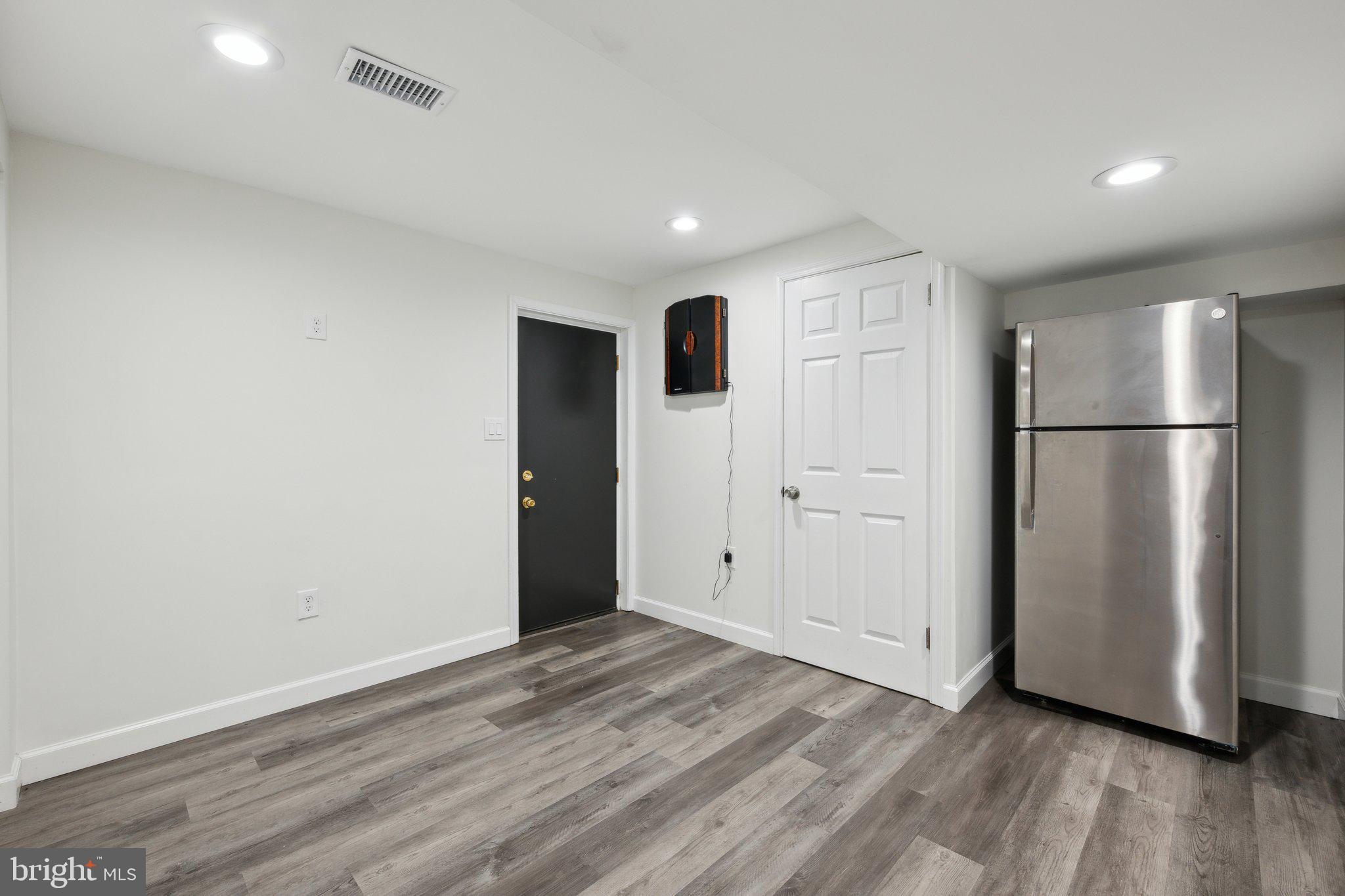 10601 Meadowhill Road Silver Spring, MD 20901 - Photo 26 of 33 a view of an empty room with wooden floor and a kitchen