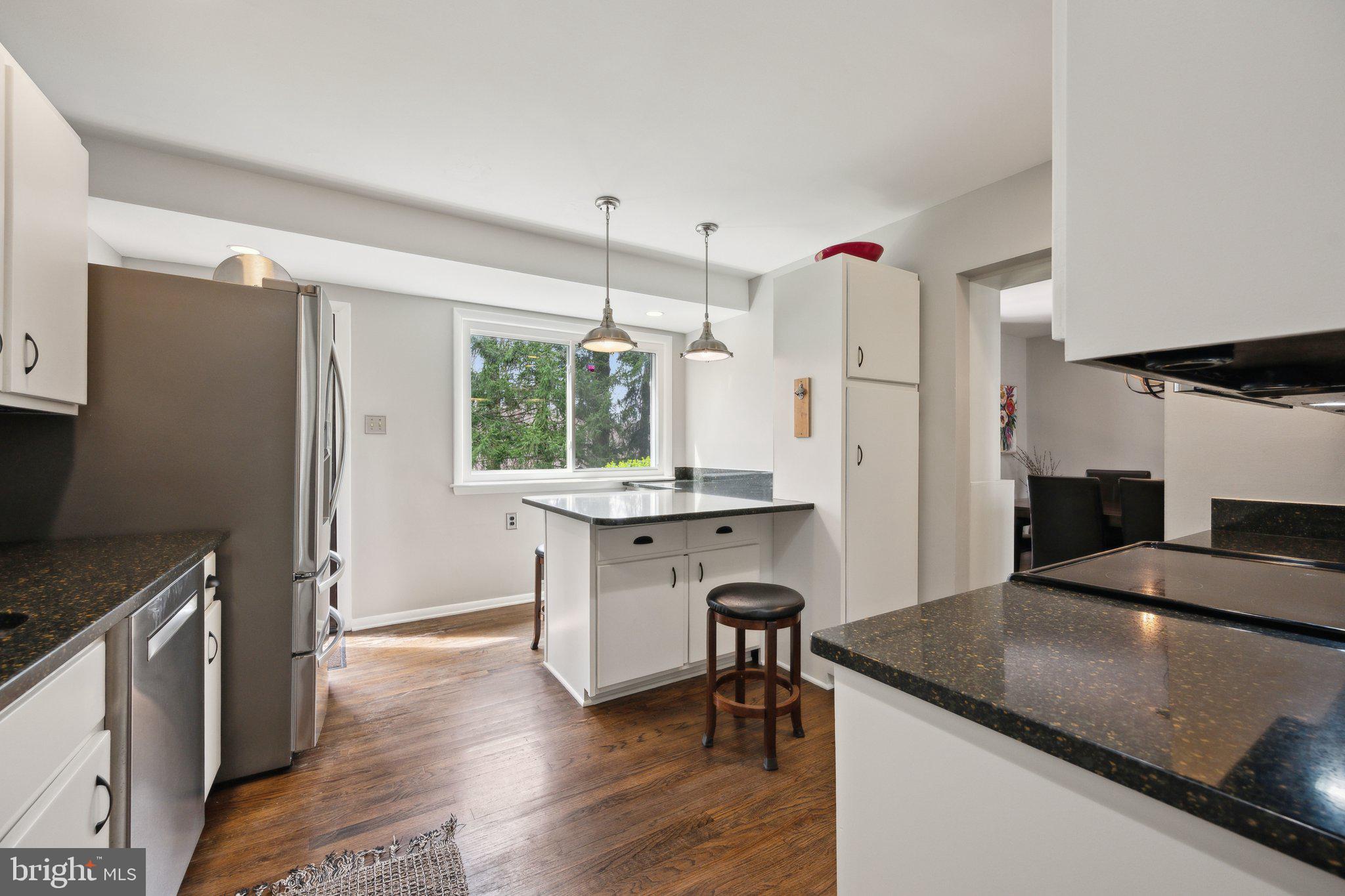 10601 Meadowhill Road Silver Spring, MD 20901 - Photo 8 of 33 a kitchen with a refrigerator a sink and white cabinets