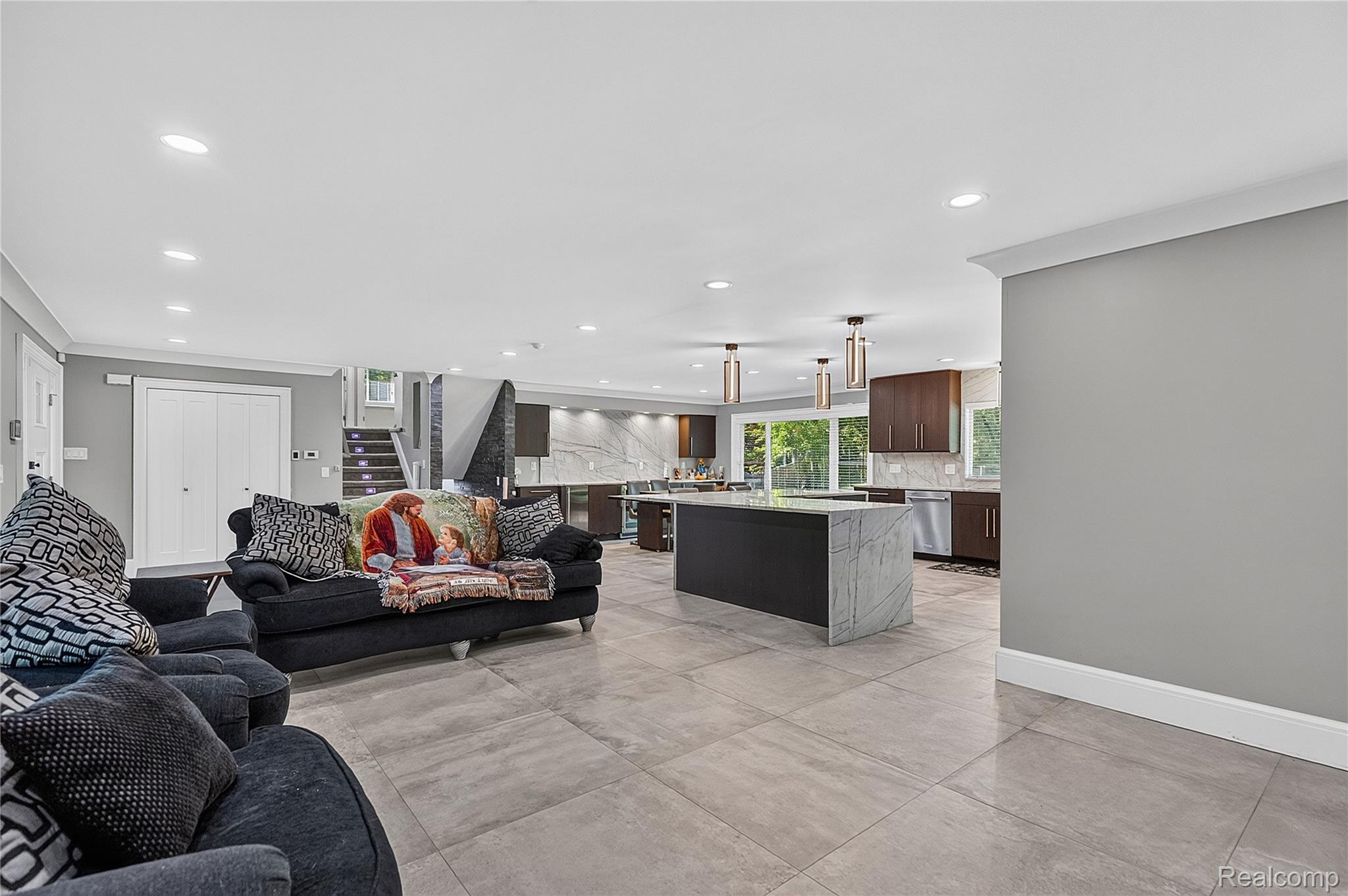 15879 Millar Road Clinton Township, MI 48036 - Photo 6 of 65 Expansive open-concept living area featuring large format tile flooring, recessed lighting, and a modern kitchen with a large island and pendant lighting