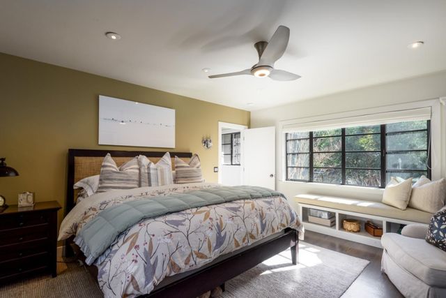 a bedroom with a bed and a large window