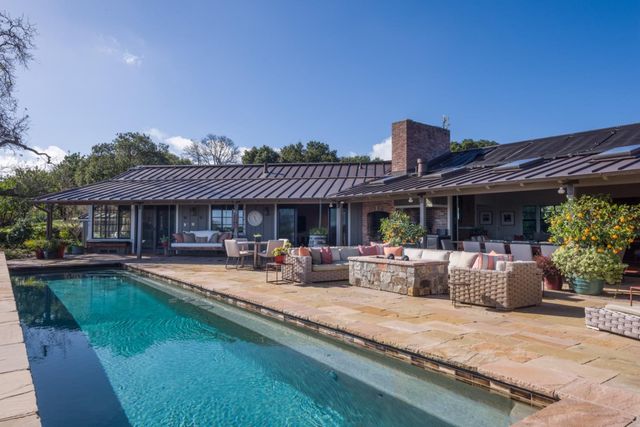 a view of a house with swimming pool and sitting area