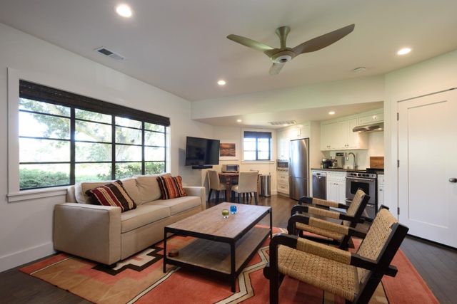 a living room with furniture a ceiling fan and a large window