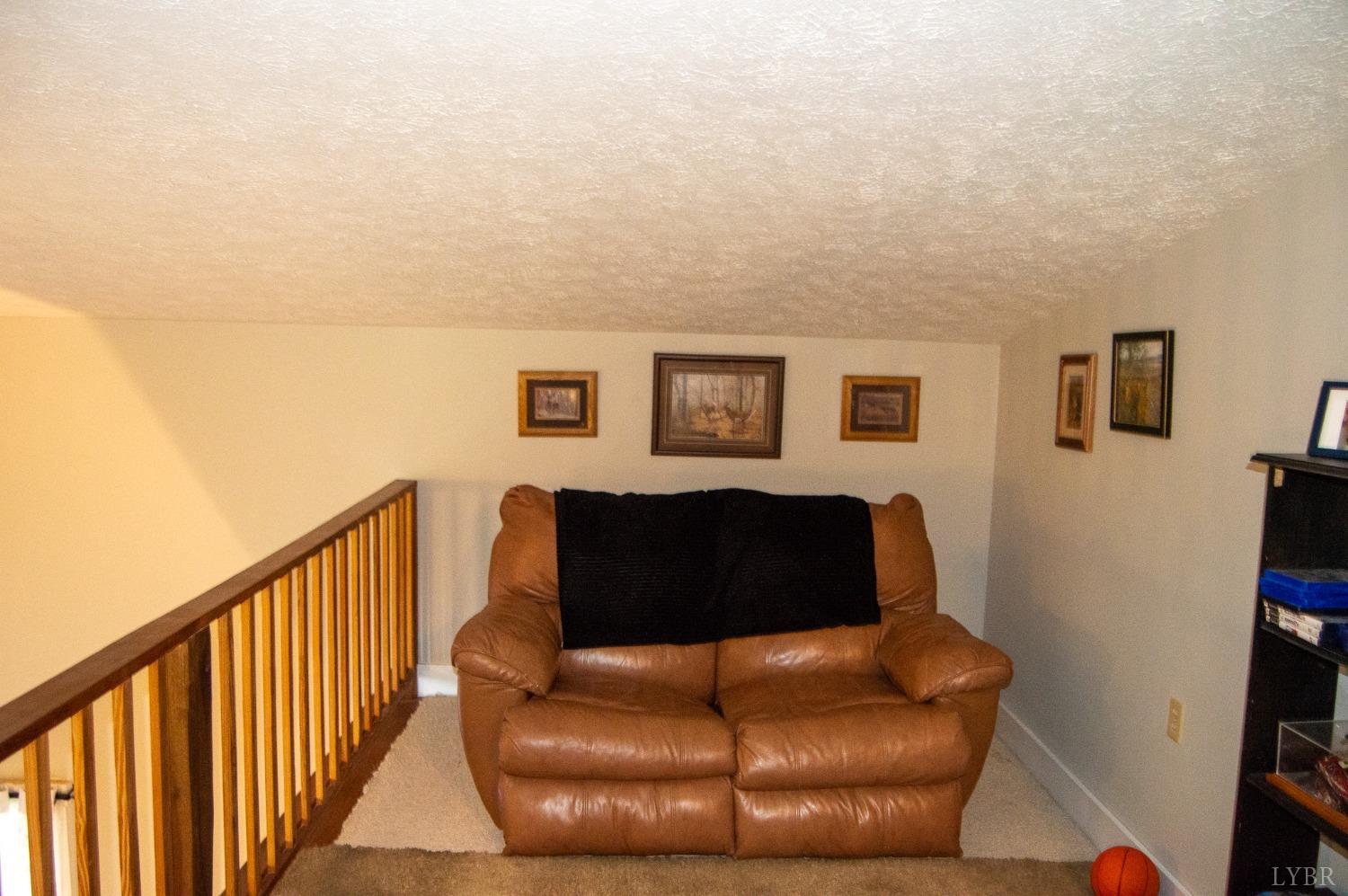 4740 Payneton Road Chatham, VA 24531 - Photo 38 of 49 a blue couch sitting in a living room next to a lamp