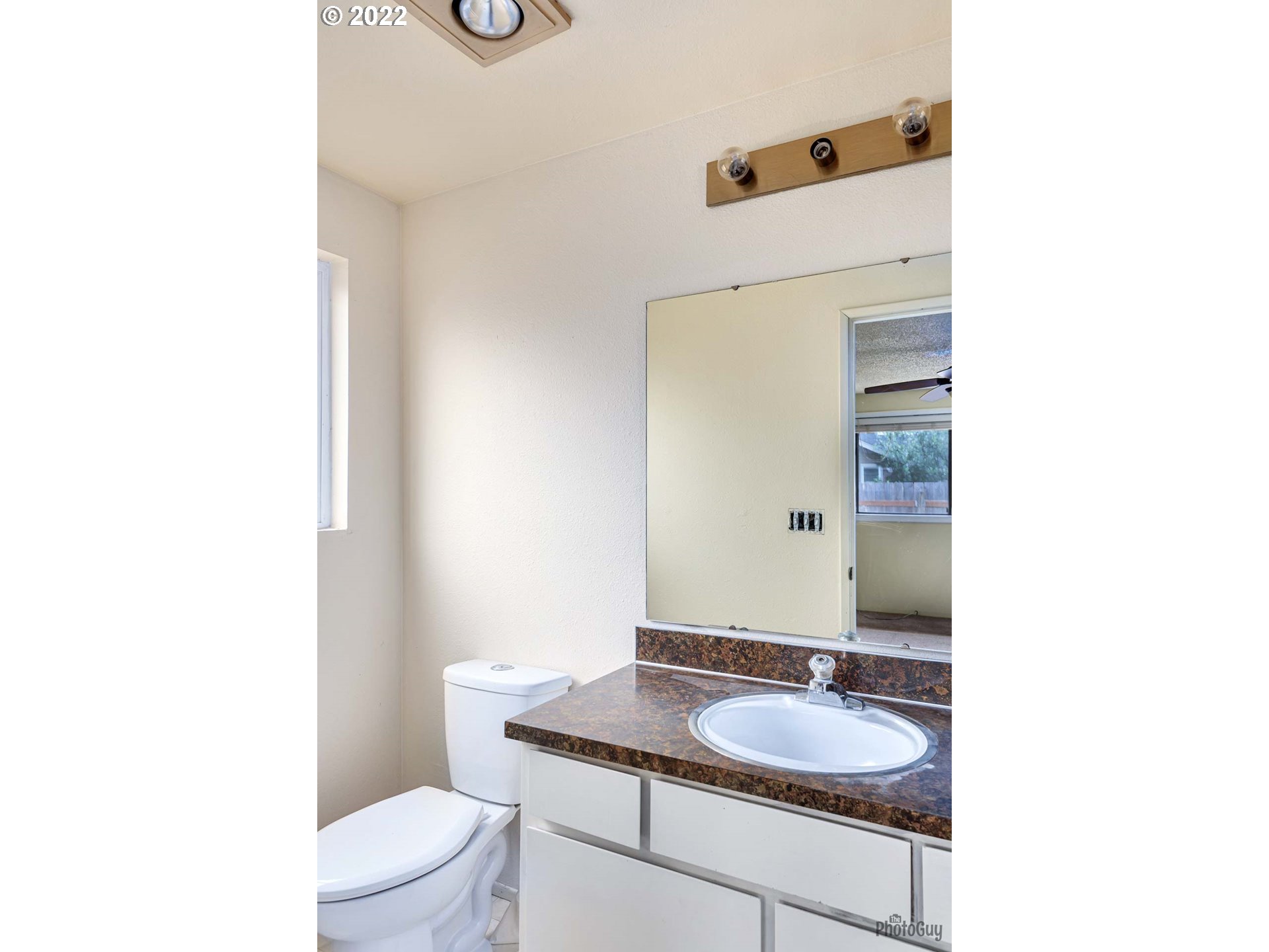 529 Sandstone Way Eugene, OR 97402 - Photo 14 of 19 a bathroom with a granite countertop sink a toilet and mirror